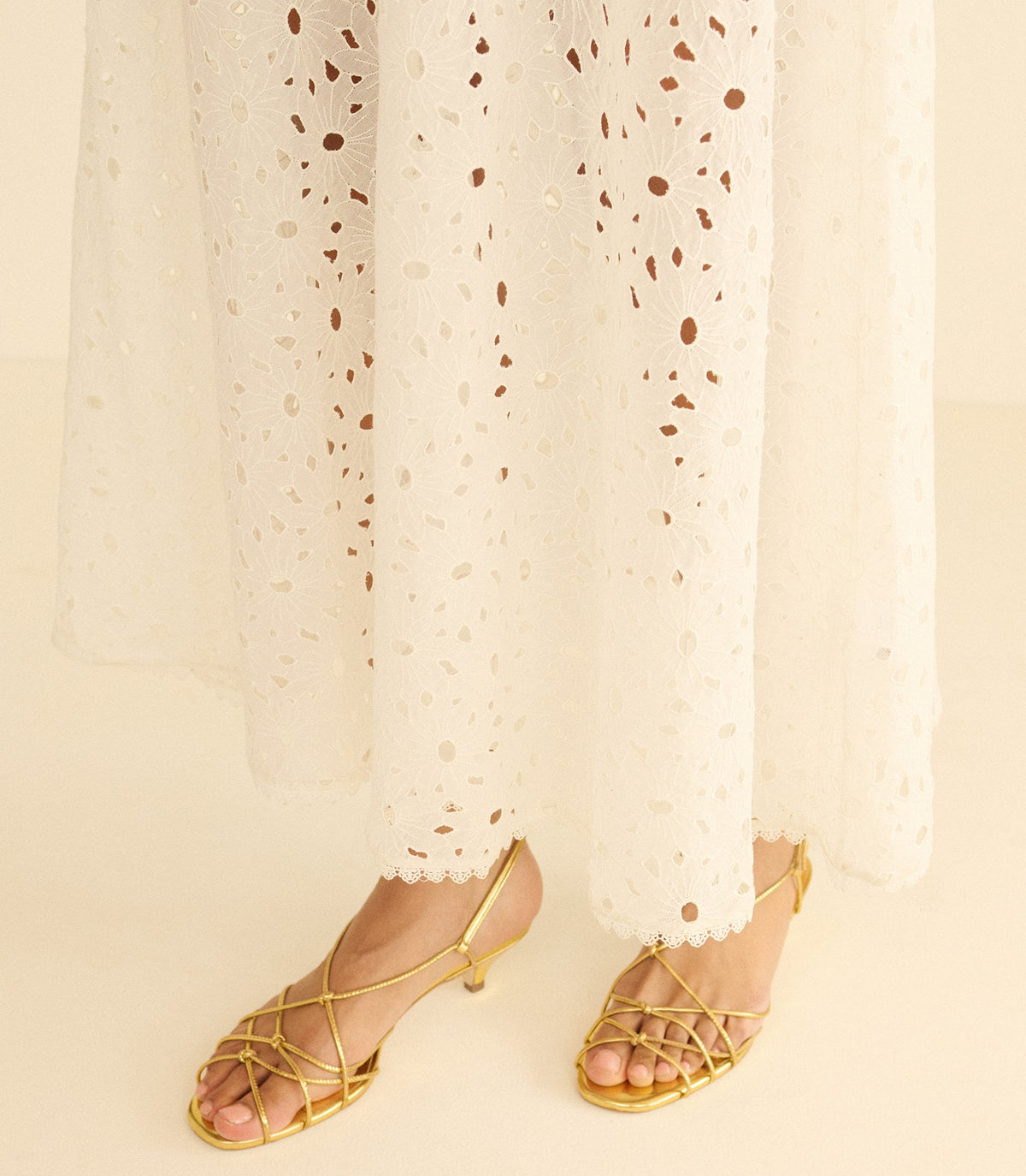 Metallic gold sandals worn with a long white skirt.